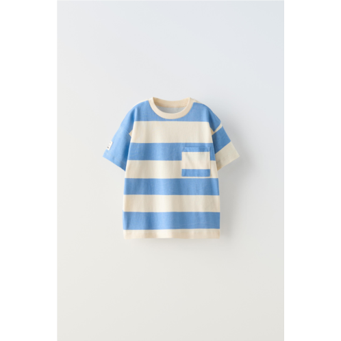 Zara Round neck T-shirt with short sleeves. Patch pocket at chest. Label applique at sleeve.